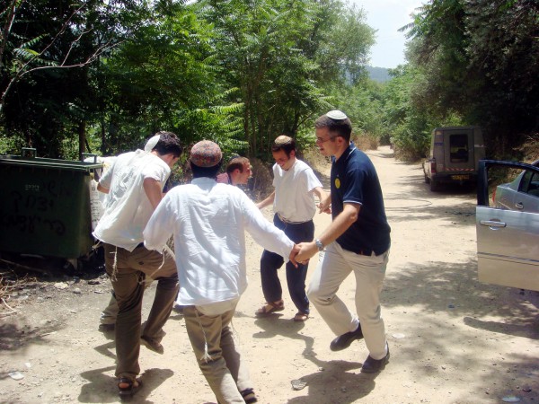 A groom rejoices by dancing with his friends after immersing himself in the mikvah. mikvah_dance_Zev