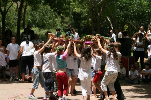 Israeli children perform a dance with offering baskets at a kibbutz on Shavuot.