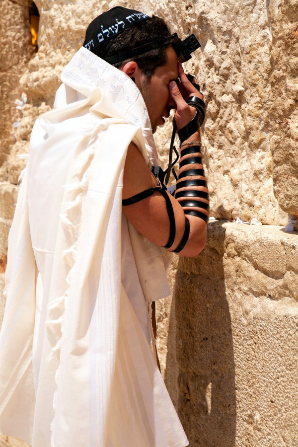 A Jewish man prays at the Wailing (Wailing) Wall in the Old City of Jerusalem wearing a tallit (prayer shawl), a kippah (head covering), and tefillin (phylacteries). (Israeli Ministry of Tourism photo by Noam Chen) A Jewish man prays at the Wailing (Wailing) Wall in the Old City of Jerusalem wearing a tallit (prayer shawl), a kippah (head covering), and tefillin (phylacteries). (Israeli Ministry of Tourism photo by Noam Chen)